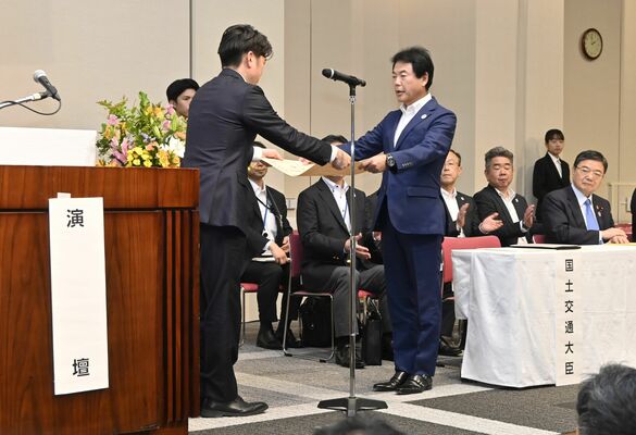 中野洋昌国土交通相（左）から賞状を受け取る佐藤市長＝５日午後、都内