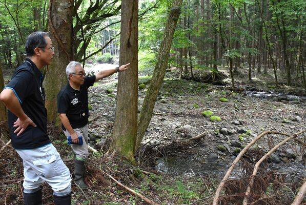 詳細調査候補地内で選定からの10年を振り返る塩谷町職員の星さん（右）ら＝25日午後、塩谷町上寺島