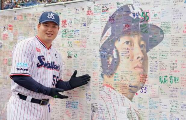 ファン感謝イベントに参加し、応援ボードの前でポーズをとるヤクルト・村上=23日、神宮