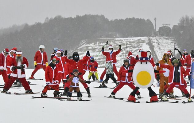 サンタクロース姿などで一斉に滑走する来場客ら＝24日午前、那須塩原市湯本塩原