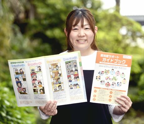 ガイドブックを手にする茂呂委員長