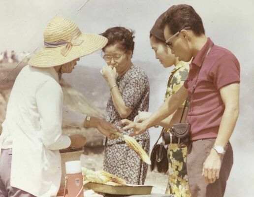 50年ほど前、阿蘇山頂付近の路上で地トウキビを販売する森繁博さんの母（左）＝（森さん提供）
