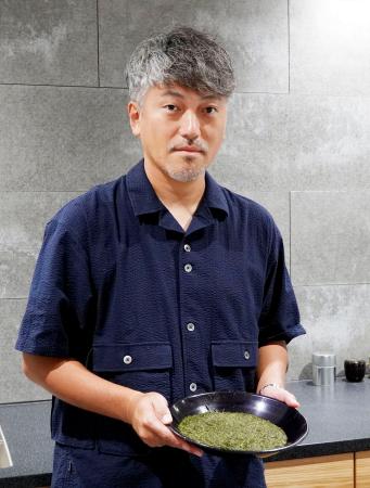 　茶葉を持つ「カネカ北川製茶」の北川弘晃さん＝２０２５年９月、静岡県島田市