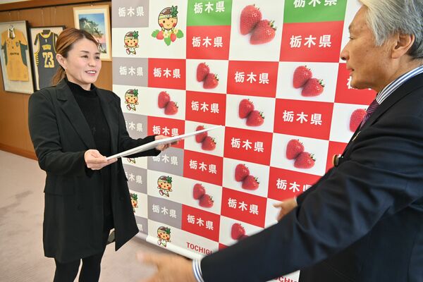 セレモニー用の名刺を受け取ったイガリさん（左）＝18日午後、県庁