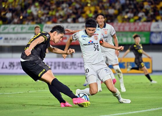 後半30分、シュートを放つ栃木ＳＣのＦＷ根本（左）＝カンセキスタジアムとちぎ