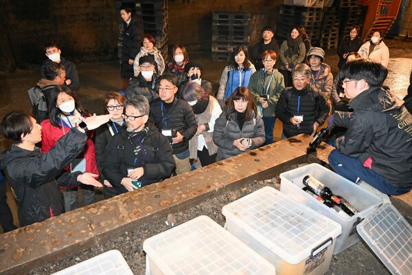 富澤マネージャー（左）からワイン熟成の説明を聞く参加者＝１３日午前、宇都宮市