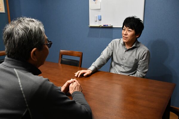 栃木ダルク職員（右）と最近の生活について話すギャンブル依存症の男性＝４日午後、宇都宮市下栗町