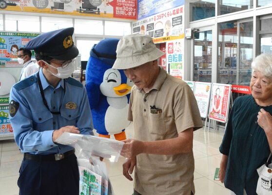 特殊詐欺被害防止に向けた啓発品などを手渡される来店者ら＝９日午前10時40分、宇都宮市今泉町