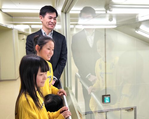 上原園の岡部社長（奥）の案内で工場を見学する華瑚さん（中央）と璃華さん