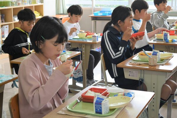 初めてのメニューを食べる児童たち