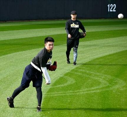 合同自主練習でキャッチボールする阪神・石井(手前)=沖縄県宜野座村