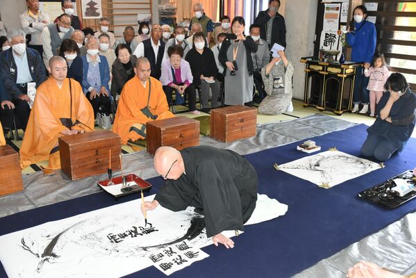 書入れを行う光明寺住職の加茂さん