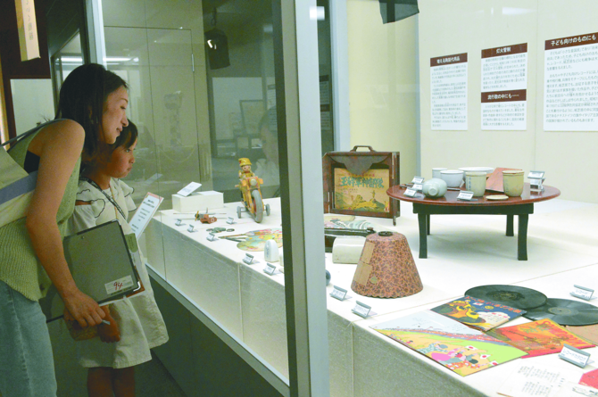 市民生活をテーマにした展示を見学する親子