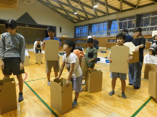 災害用の段ボールベッドを組み立てる子どもたち