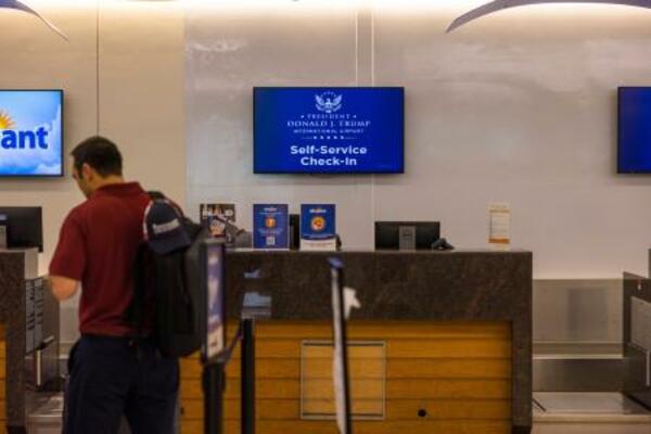 「ドナルド・J・トランプ大統領国際空港」という名称を映し出すチェックインカウンターのモニター=9日、フロリダ州(AP=共同)