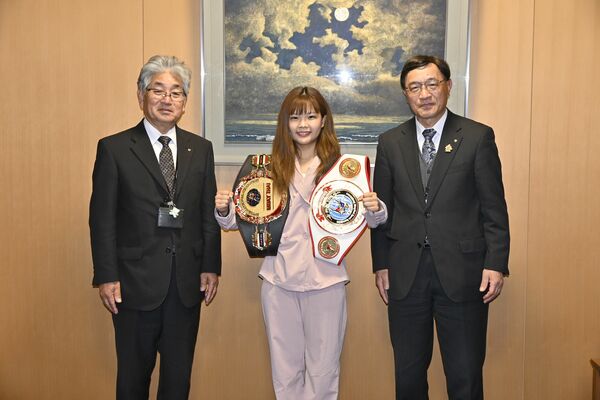 二つのベルトを手に、小菅町長（左）を表敬訪問した細貝さん