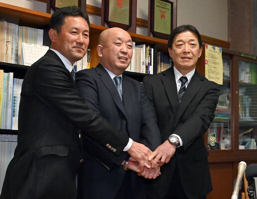 21世紀枠で初のセンバツ出場が決まり、手を取り合って喜ぶ石橋高の瀬端校長（中央）、野球部の福田監督（左）、大山部長＝27日午後、下野市石橋