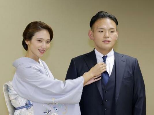 昨年10月、引退相撲の断髪式を終えて妻の有希奈さん(左)からネクタイを直してもらう元大関貴景勝の湊川親方=両国国技館