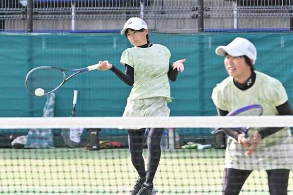 ソフトテニス女子団体決勝リーグ白鴎足利－大田原女戦　フォアハンドを決める白鴎足利の螺良（左）。手前は富山＝県総合運動公園テニスコート