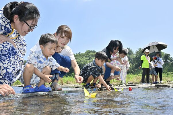 思川に下野人形を乗せた小舟を流す子どもら＝６日午前10時50分、小山市小山、森田大地撮影