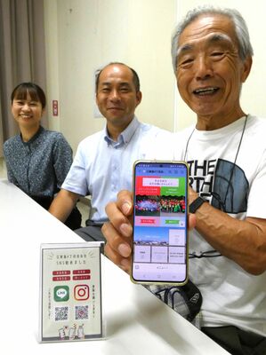 スマートフォンに届くデジタル回覧板を紹介する山口会長（右）ら自治会役員