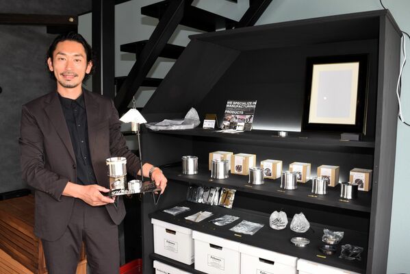 ショールームに展示されたオリジナル商品を手にする戸頃専務＝真岡市