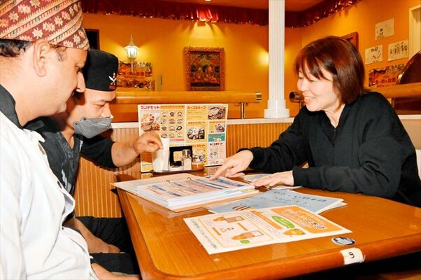 外国人の生活支援などに取り組む「ＨＡＫＵＮＡ　ＭＡＴＡＴＡ」の森仁己さん（右）。「やさしい日本語」で丁寧にやりとりをする＝１１月下旬、今治市内