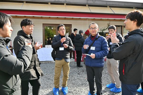 試飲する参加者に大谷熟成ワインの魅力を説明するシュヴァリエの富澤マネージャー（右）＝１３日午後、宇都宮市