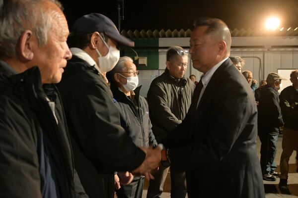 1票差で落選し、支持者と握手する小山田氏=22日午後8時45分、那須町寺子乙