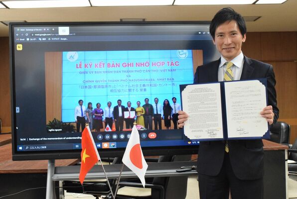 覚書に署名した渡辺市長。画面はカントー市の関係者
