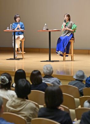 新聞記事や本県の魅力などについて話す井上さん（右）＝20日午後２時50分、小山市駅東通り２丁目、磯真奈美撮影