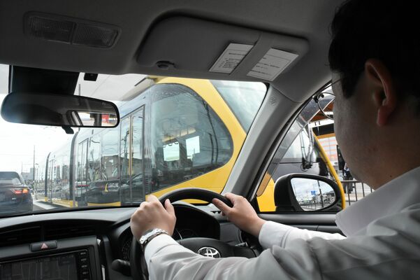 ３件目の事故現場近くで記者運転の乗用車の隣を走行するＬＲＴ＝22日午前11時45分、宇都宮市陽東５丁目