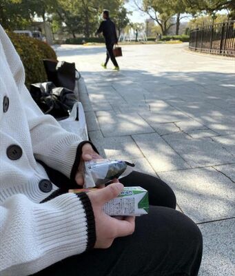 原爆ドーム前のベンチで「ごみ箱がなくなって困った」と話す大学生