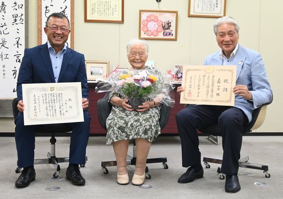 福田知事（右）と星野町長（左）から花束と祝詞を贈呈され、笑顔の上野さん