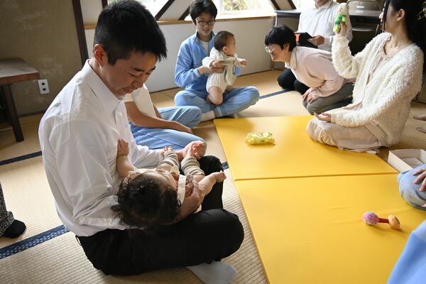 慣れない手つきで赤ちゃんを抱く中学生
