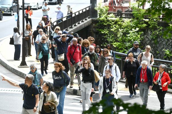 神橋前の横断歩道を渡り、世界遺産の二社一寺方面に向かう外国人観光客たち＝１４日午前、日光市山内