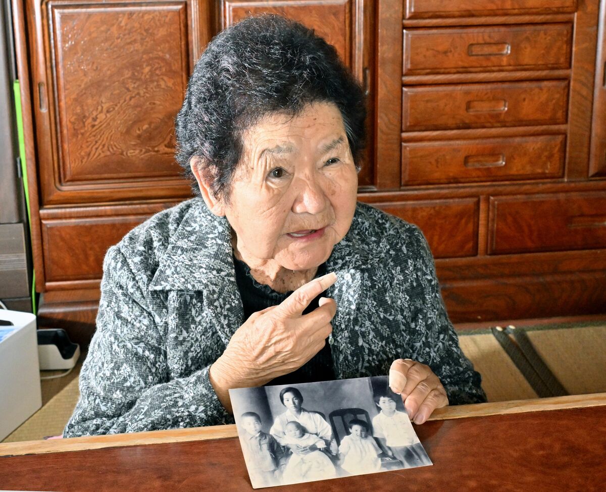 満州から唯一持ち帰った家族写真を手に、当時を振り返る中島さん。写真右端が幼少期の中島さん＝10月下旬、那須町豊原丙