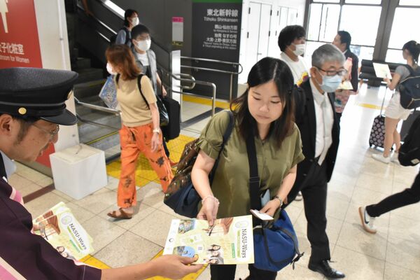 ナスウェイズのチラシを受け取る駅利用者