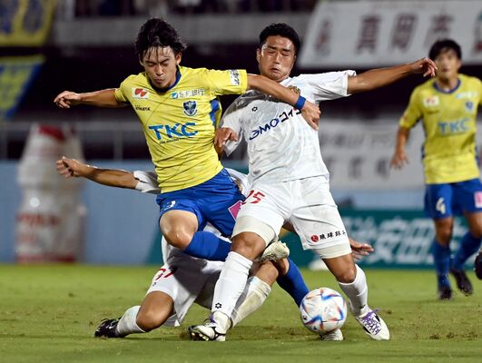 前半21分、相手選手と競り合う栃木ＳＣのＭＦ植田（左）＝県グリーンスタジアム