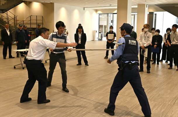 警察官の指導で不審者の対応訓練を行うライトキューブの職員ら＝５日午前、宇都宮市宮みらい