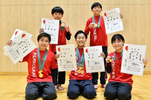 団体戦・基本動作を制した（前列左から）磯慶多さん、平山さん、磯芽依さんの３人。江連さん（後列左）と桜井さんは個人部門で優勝した