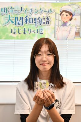 大関をキャラクター化したイラスト入りの新グッズ。後ろは「当たり景品」のタオル