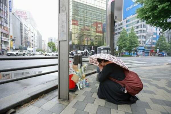 東京・秋葉原の無差別殺傷事件現場となった交差点で手を合わせる人=8日午前