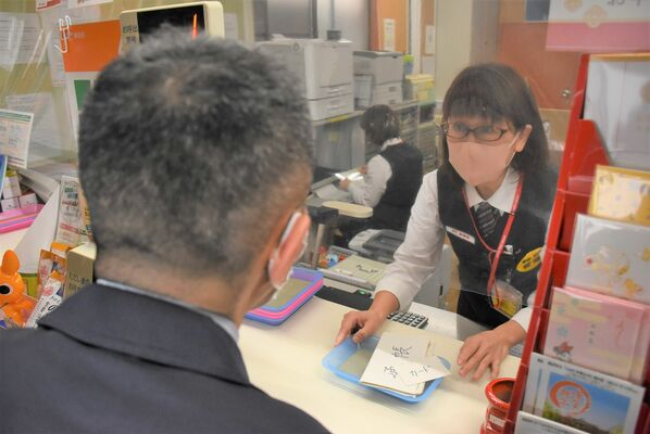 架空請求詐欺を想定した訓練で、現金の使途を確認する局員