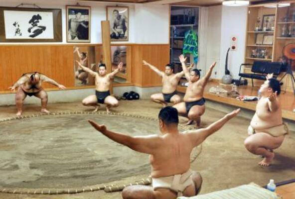 　新師匠の大嶽親方（手前）の下で稽古に臨む王鵬（右端）ら。奥は元横綱大鵬の写真＝東京都江東区の大嶽部屋