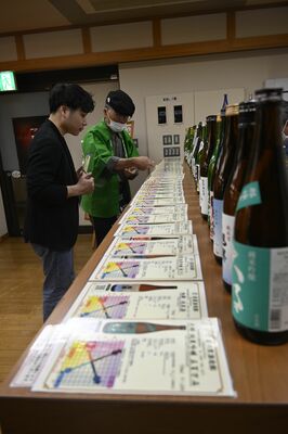 スタッフの説明を受けながら銘柄を選ぶ観光客