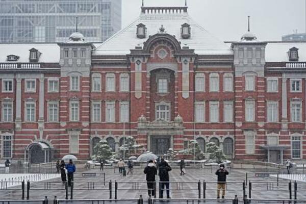 　雪が降る中、ＪＲ東京駅前を訪れた人たち＝８日午前