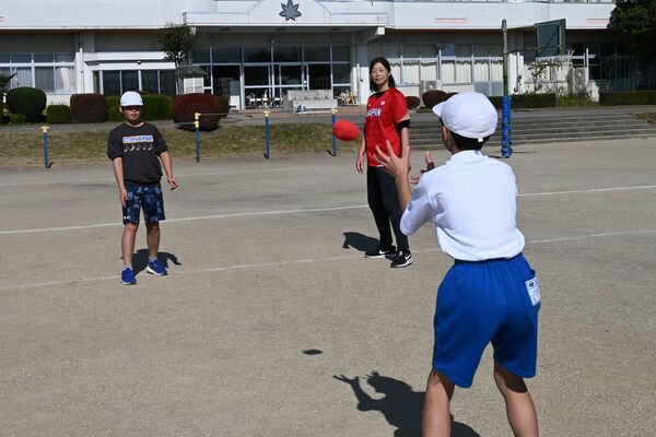 児童にキャッチボールのコツを指導する坂井さん