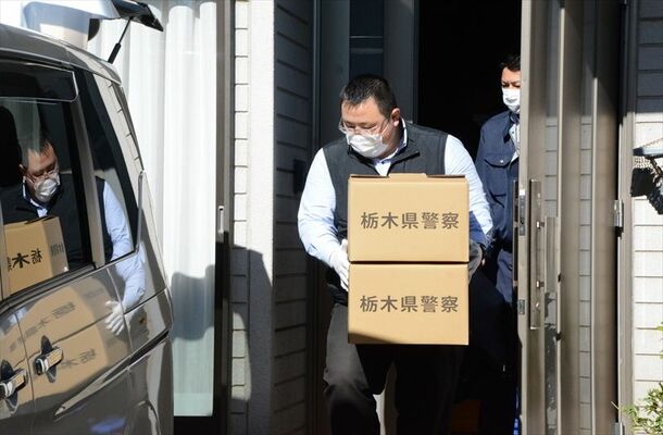 男の自宅を家宅捜索し、押収品を入れた段ボール箱を運ぶ捜査員＝22日午後０時55分、埼玉県熊谷市