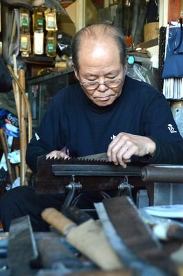 戦前の古いのこぎりの目立てを行う関根さん
